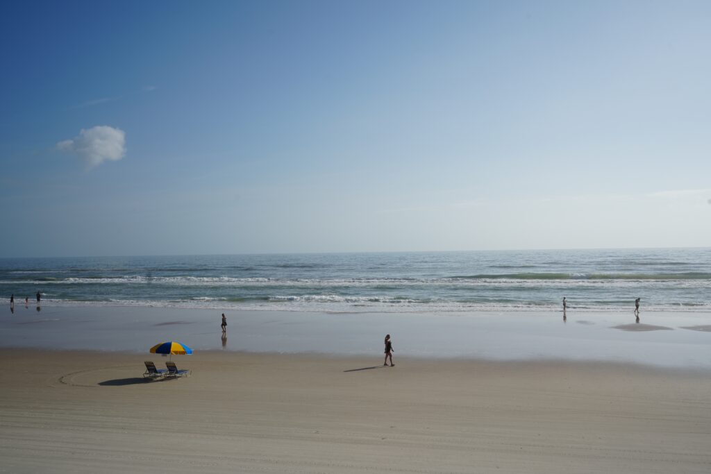 Peaceful view of the Daytona Beach shoreline near Ambros Hotel, showcasing a serene coastal setting under a clear blue sky