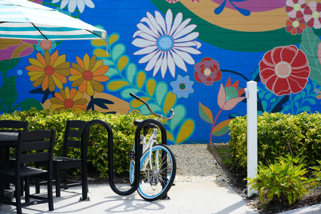 Bright floral mural with bike rack and café seating at Casual Bird