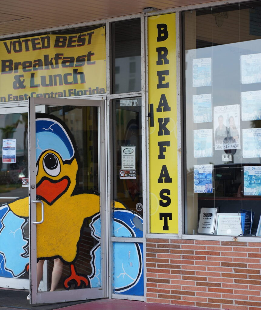 Front entrance of The Cracked Egg Diner with duck mural and breakfast signage