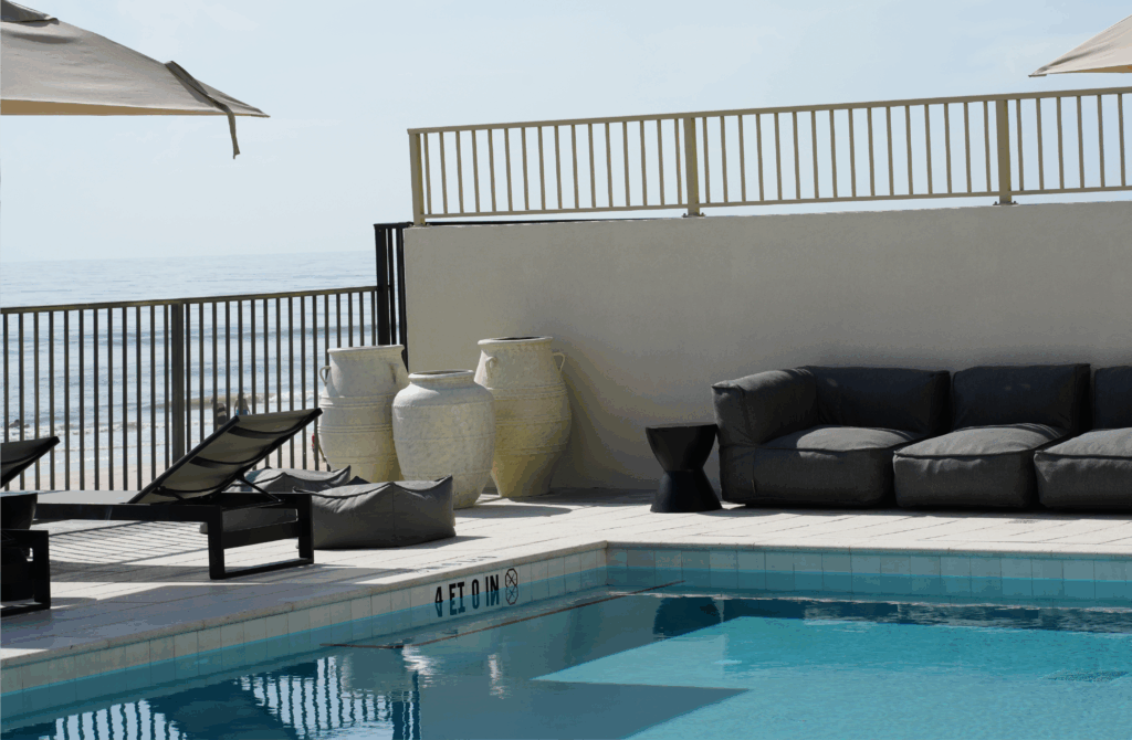 Modern poolside lounge at The Counter with ocean views and designer outdoor seating.