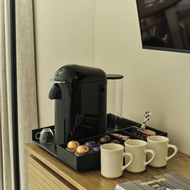 In-room Nespresso coffee station at Ambros Hotel with mugs, pods, and modern setup